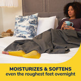 Person wearing yellow foot sleeves with Dr. Scholl's overnight foot treatment tube