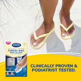 Light-activated fungal nail treatment box with compact nail revitalizer device beside sandals