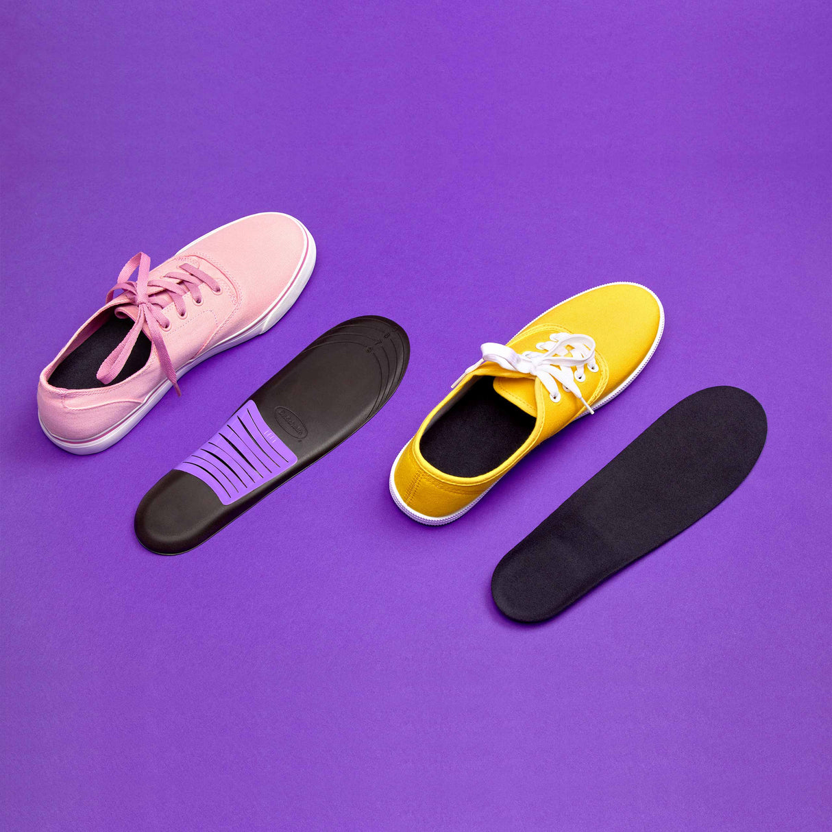 Set of sneaker insoles in black, pink, and yellow with cushioned top layer