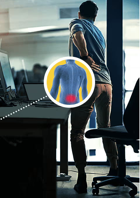 Person experiencing back pain in an office setting with a highlighted area on their back.