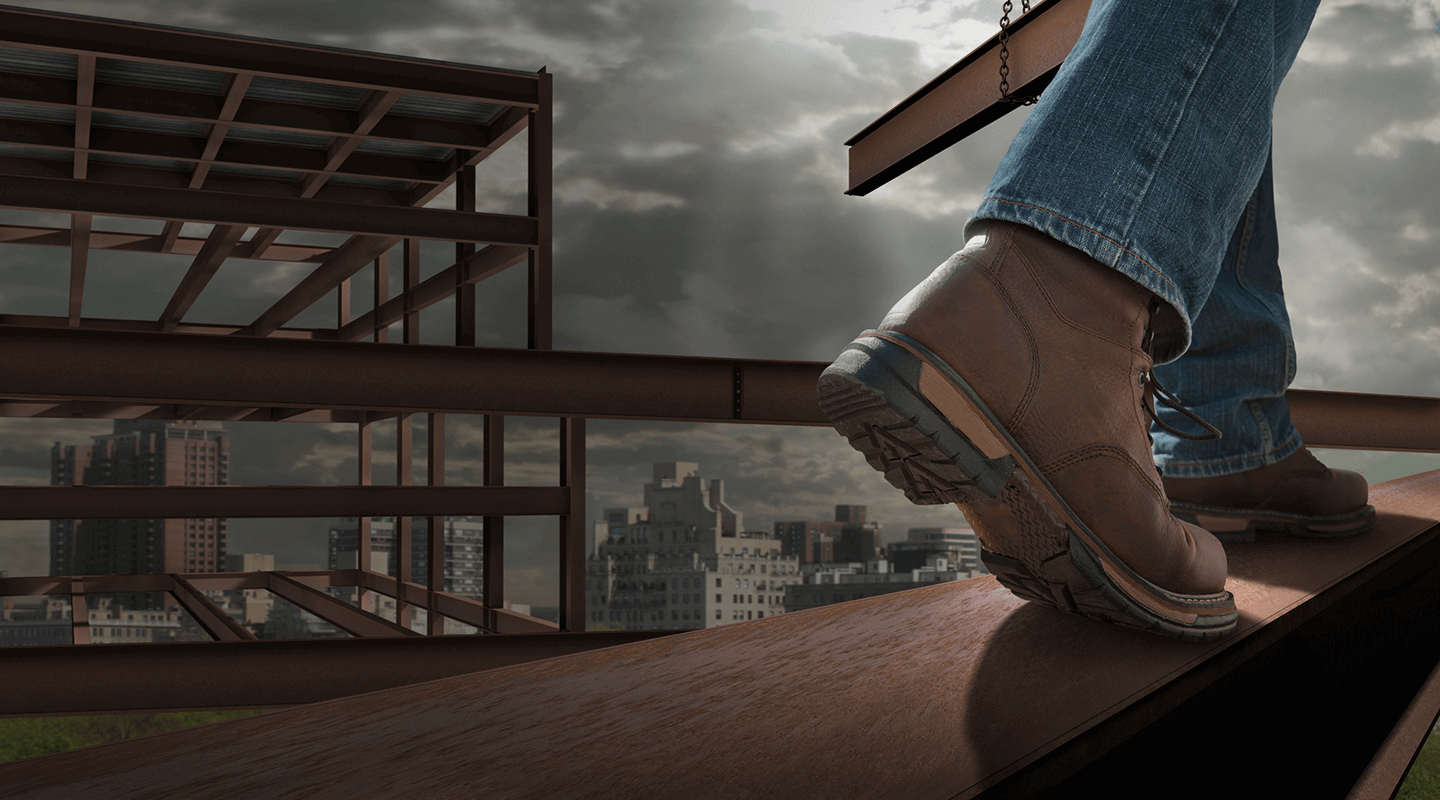 Closeup of someone in work boots walking on a girder.