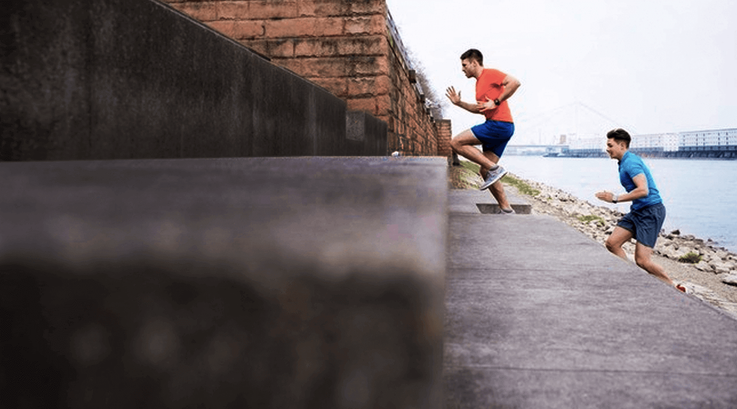 Photo of two men running up stairs.